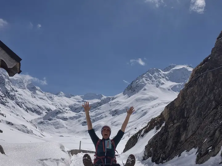Christina reckt im verschneiten Hochtal beide Arme in die Höhe